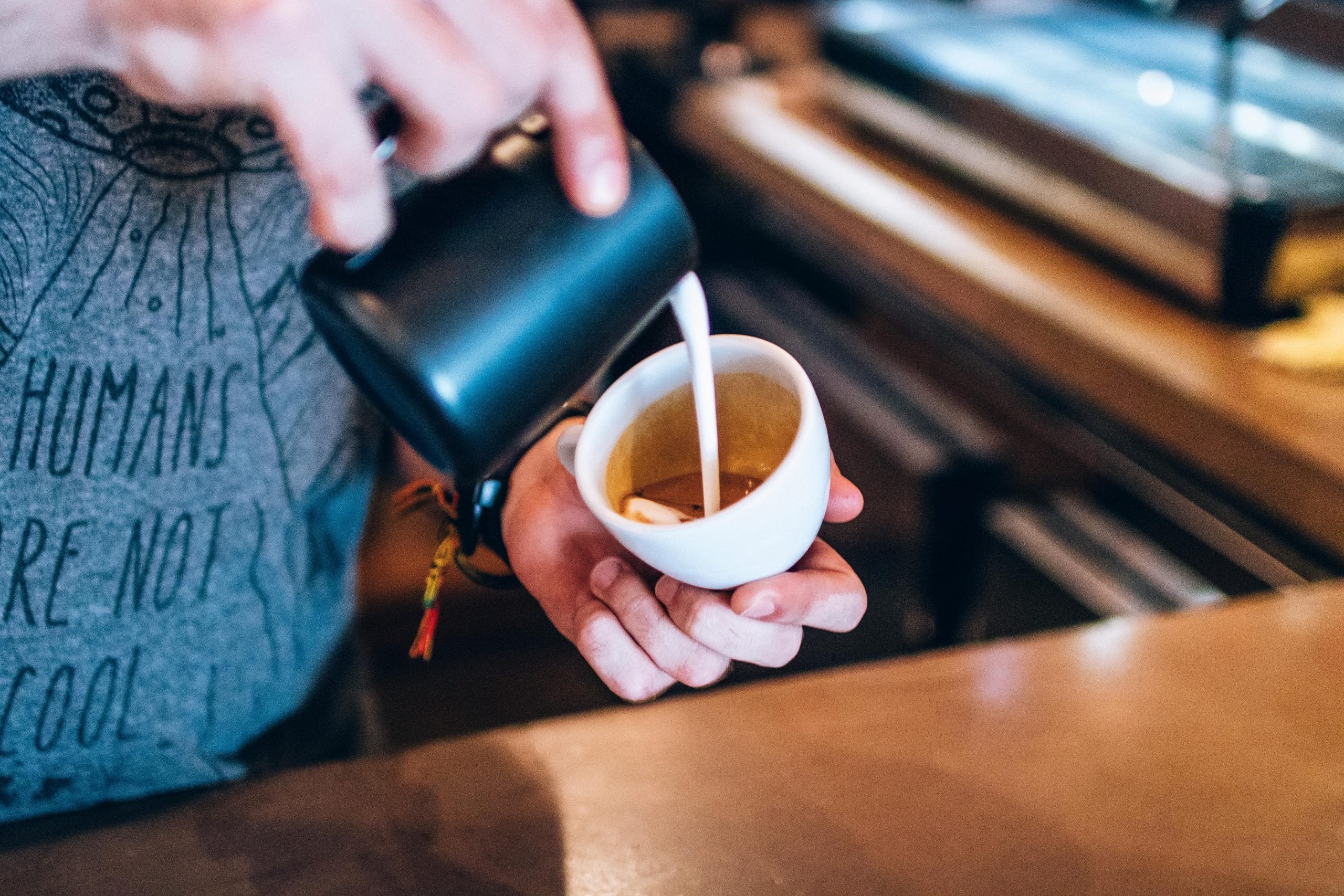 Homem preparando latte art em xícara branca