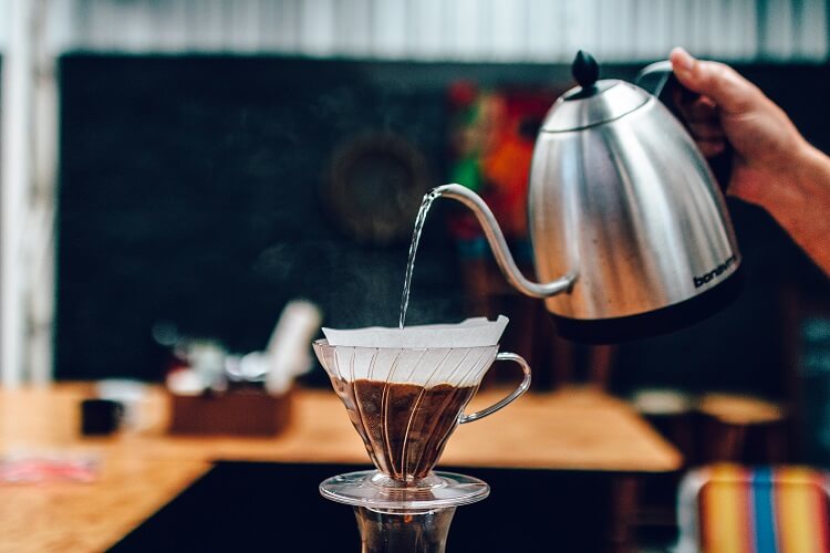 Café sendo preparado em v60 com bule bico de ganso