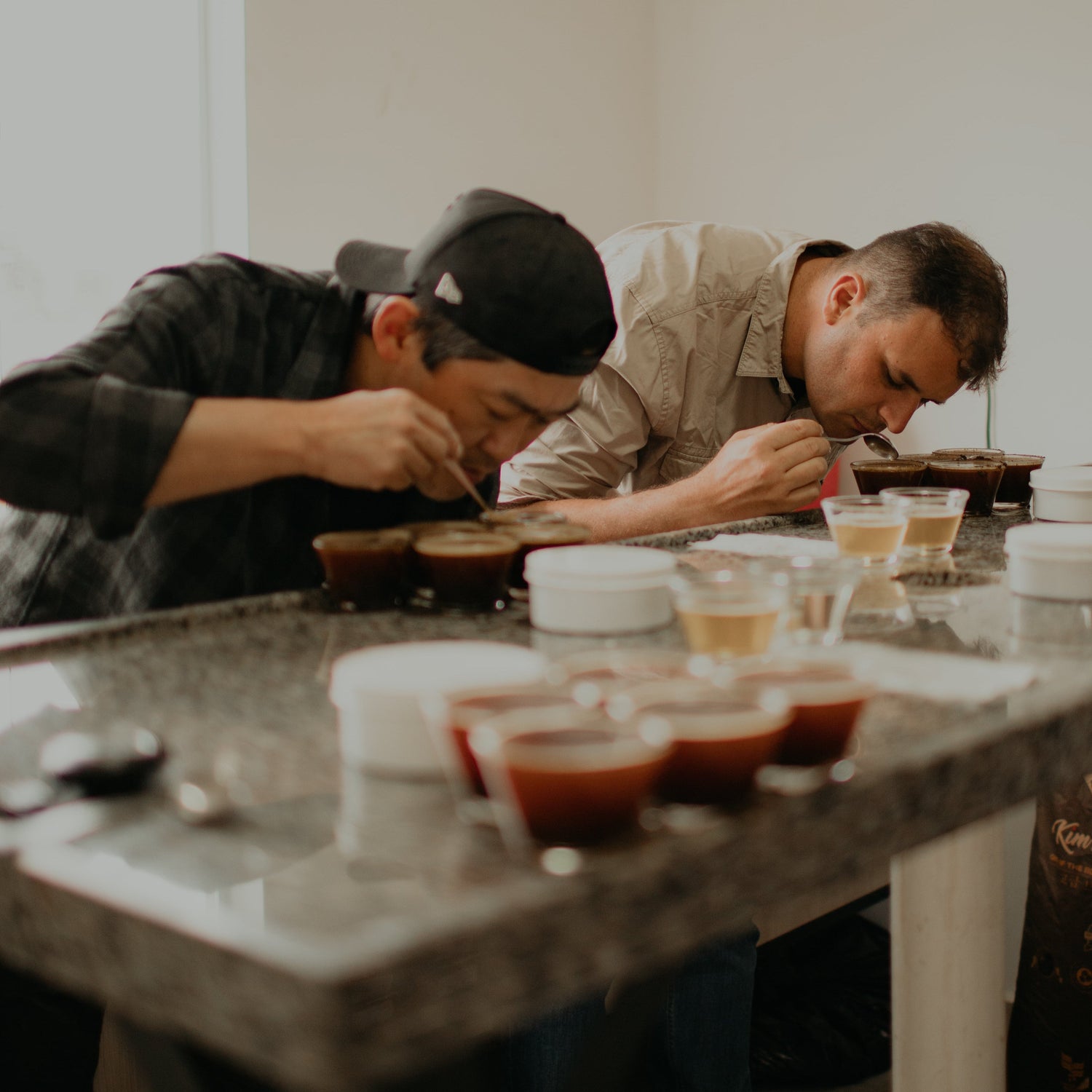 Homens provando cafés em copos de vidro
