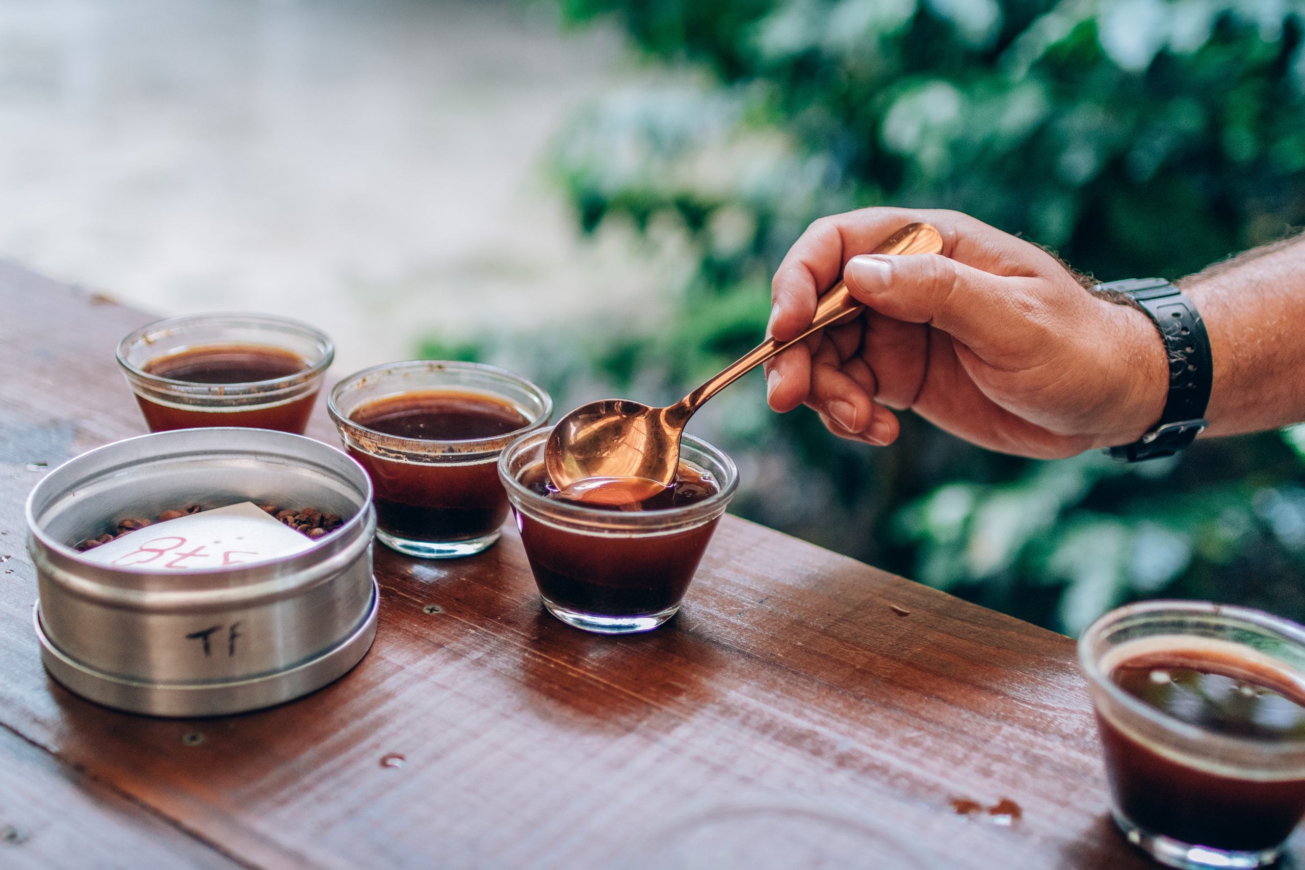 mesa de madeira com copos de cupping e homem segurando colher