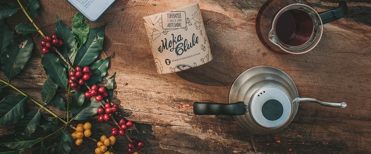 pacote de cafe bule e decanter em cima de mesa de madeira