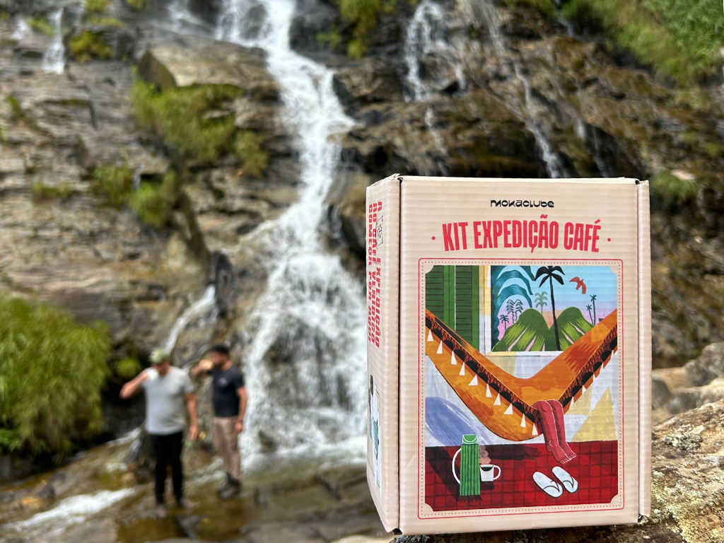 Caixa pequena na frente de cachoeira com homens bebendo café