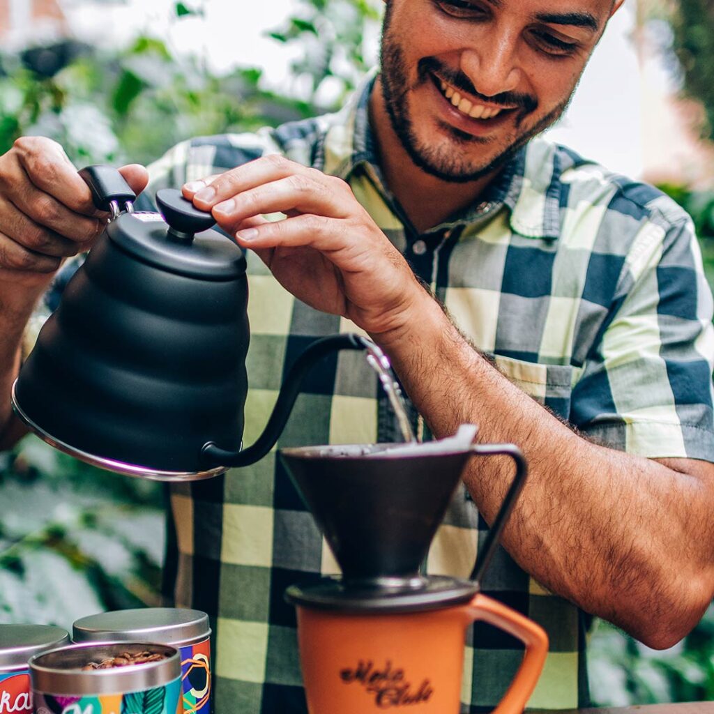 Homem segurando chaleira preta para fazer café coado